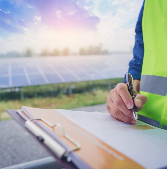 Electrical and instrument technician make a note statistic chart electric system at solar panel field